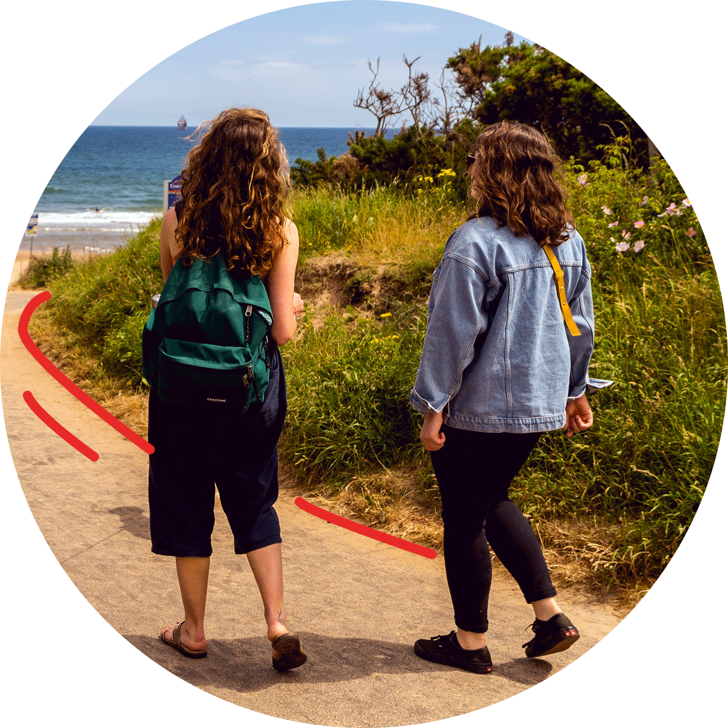 Two people walking towards the beach